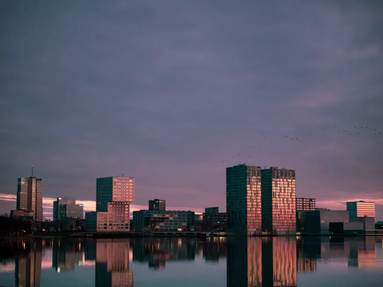 Moderne gebouwen aan een stadsmeer met een wandelpad langs het water